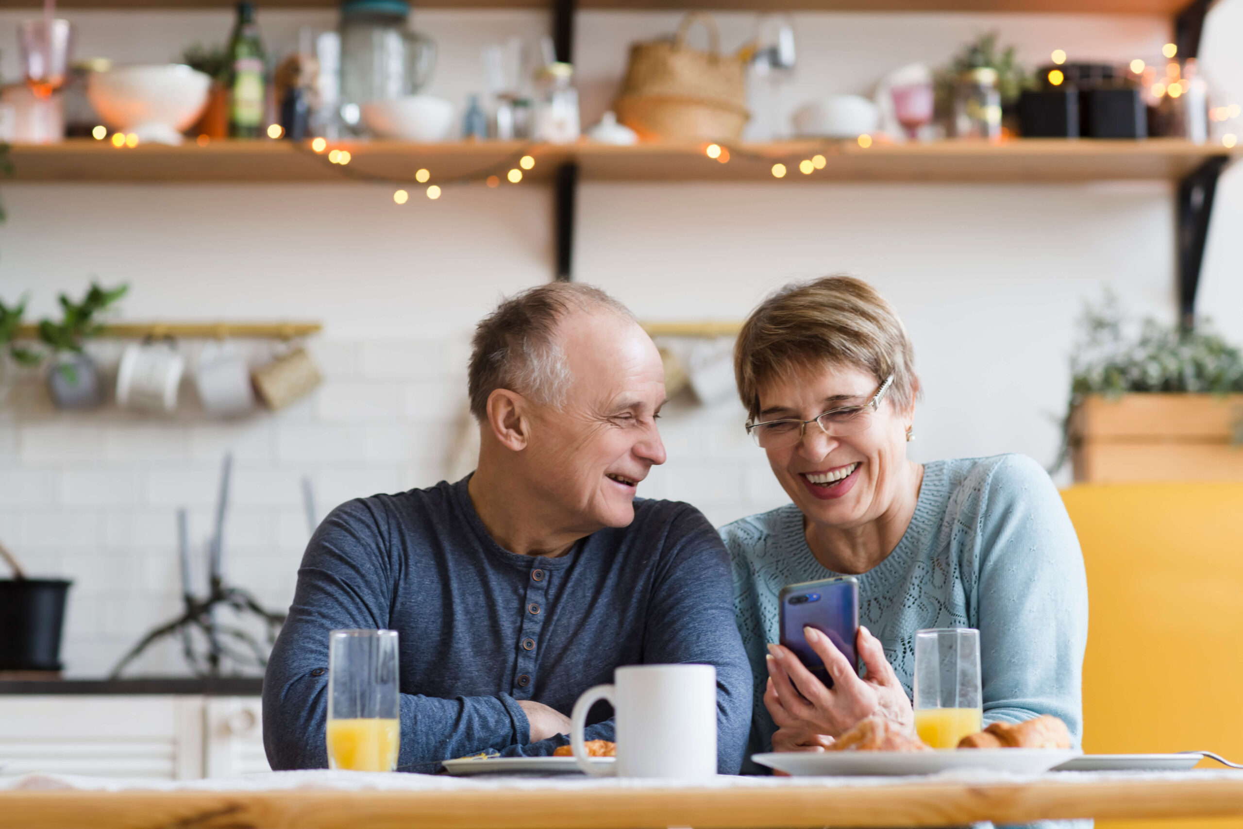 Mature couple on phone at breakfast