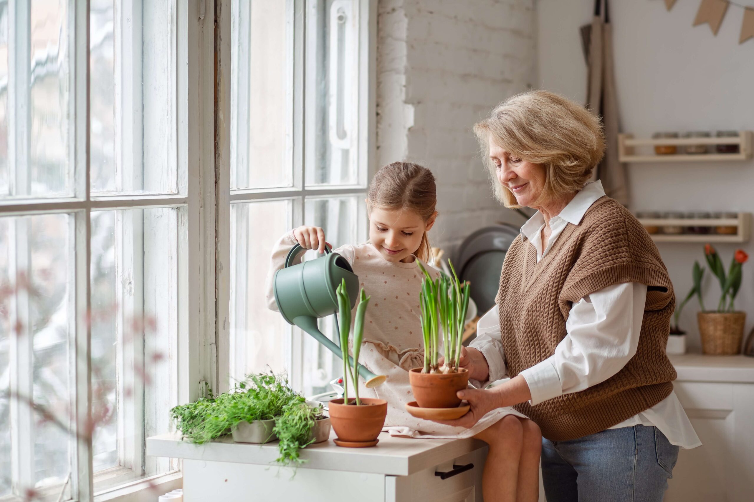 grandma and granddaughter watering plants