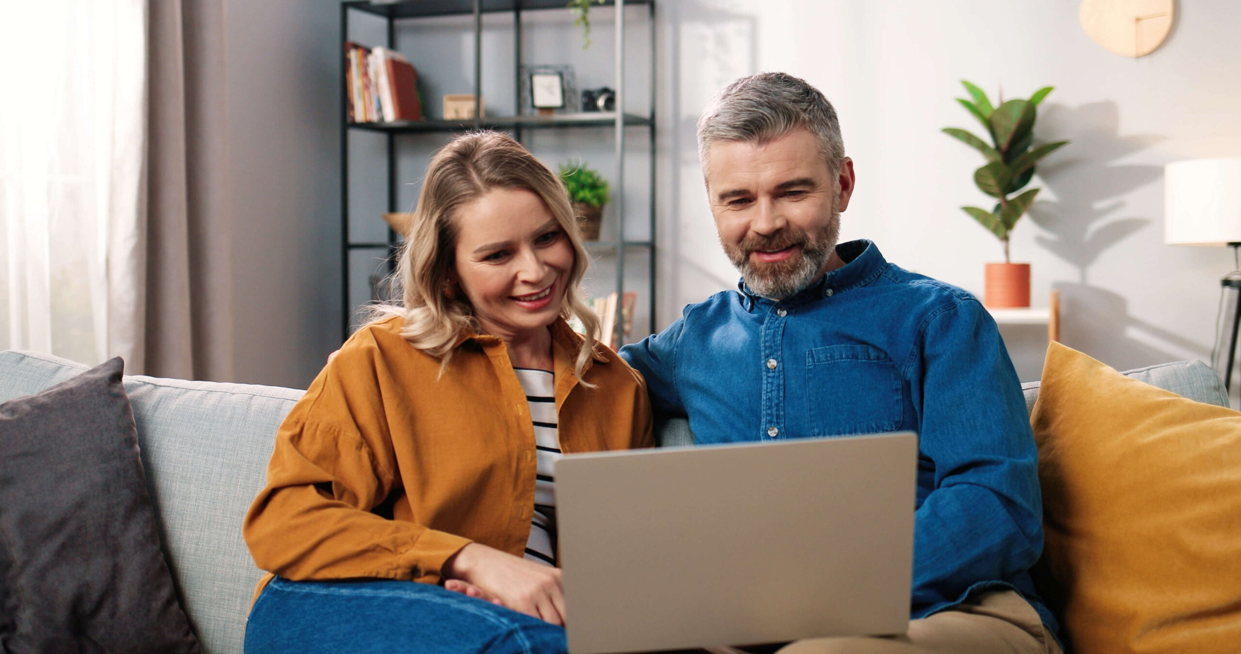 mature couple on sofa with laptop