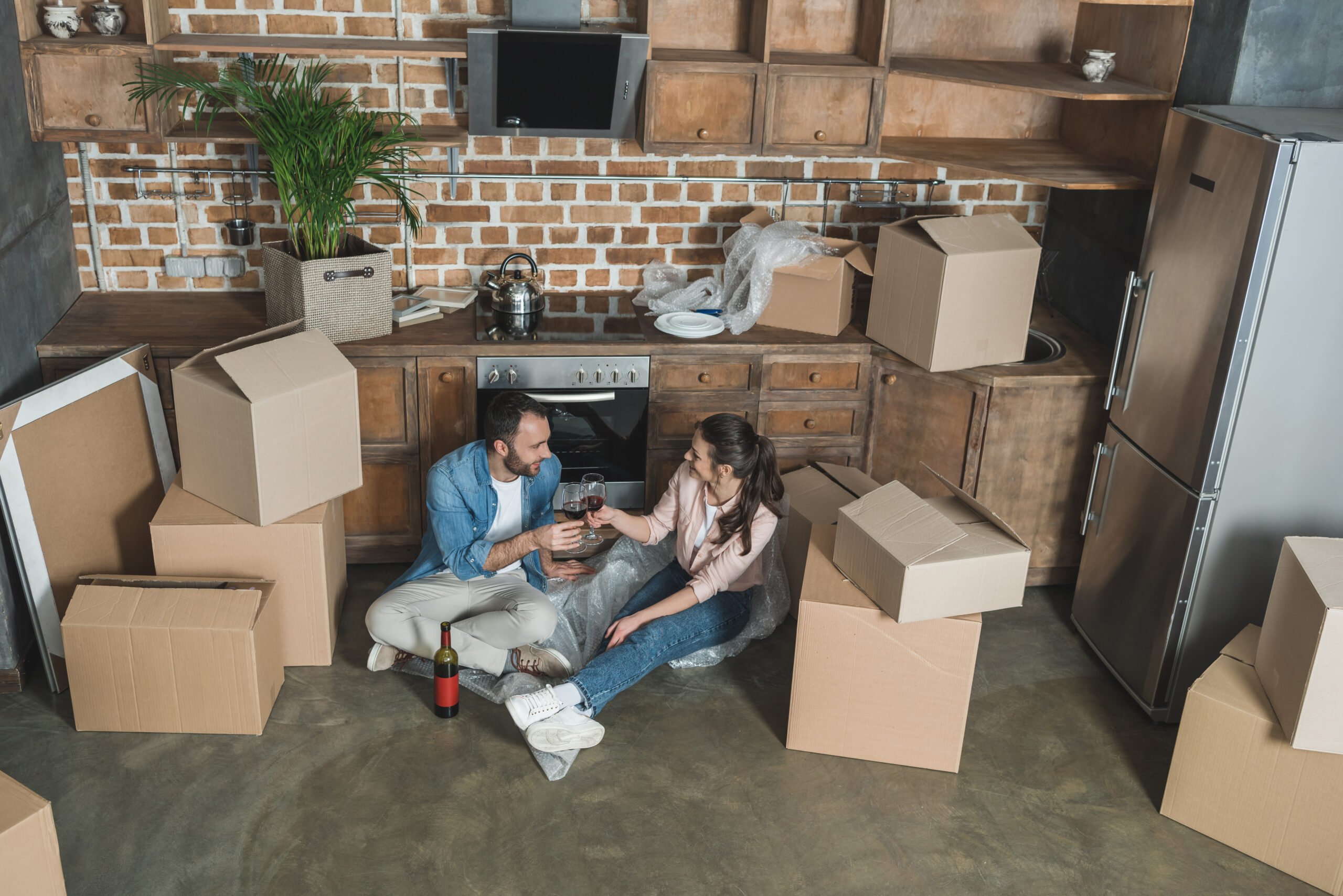 High,Angle,View,Of,Couple,Drinking,Wine,And,Celebrating,Relocation