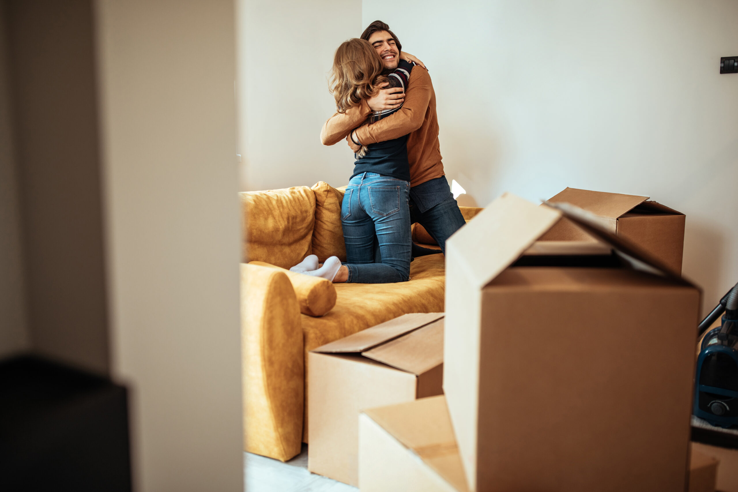 Excited,Young,Couple,Hugging,In,Their,New,Home