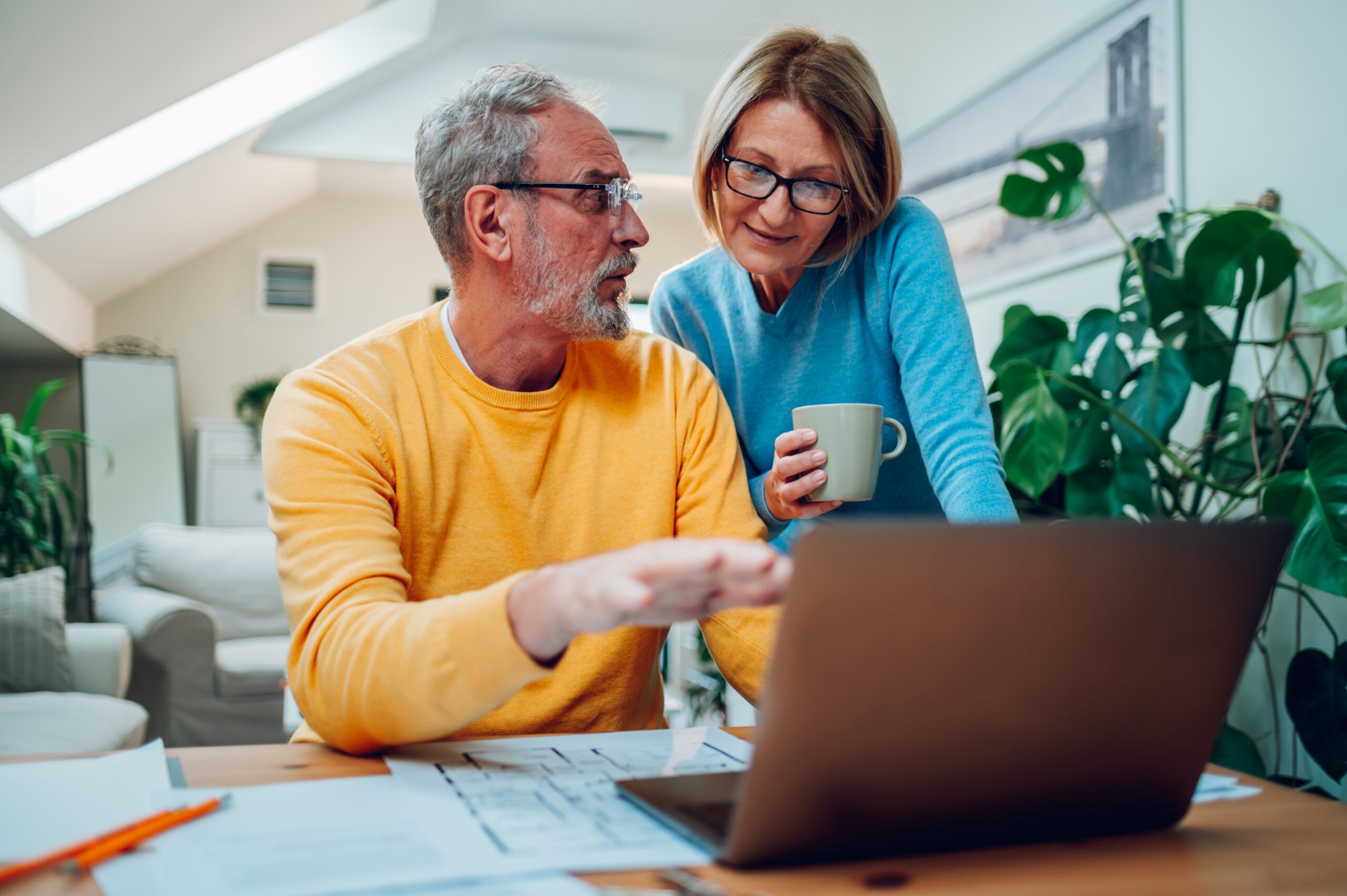 Mature couple looking at laptop together at home
