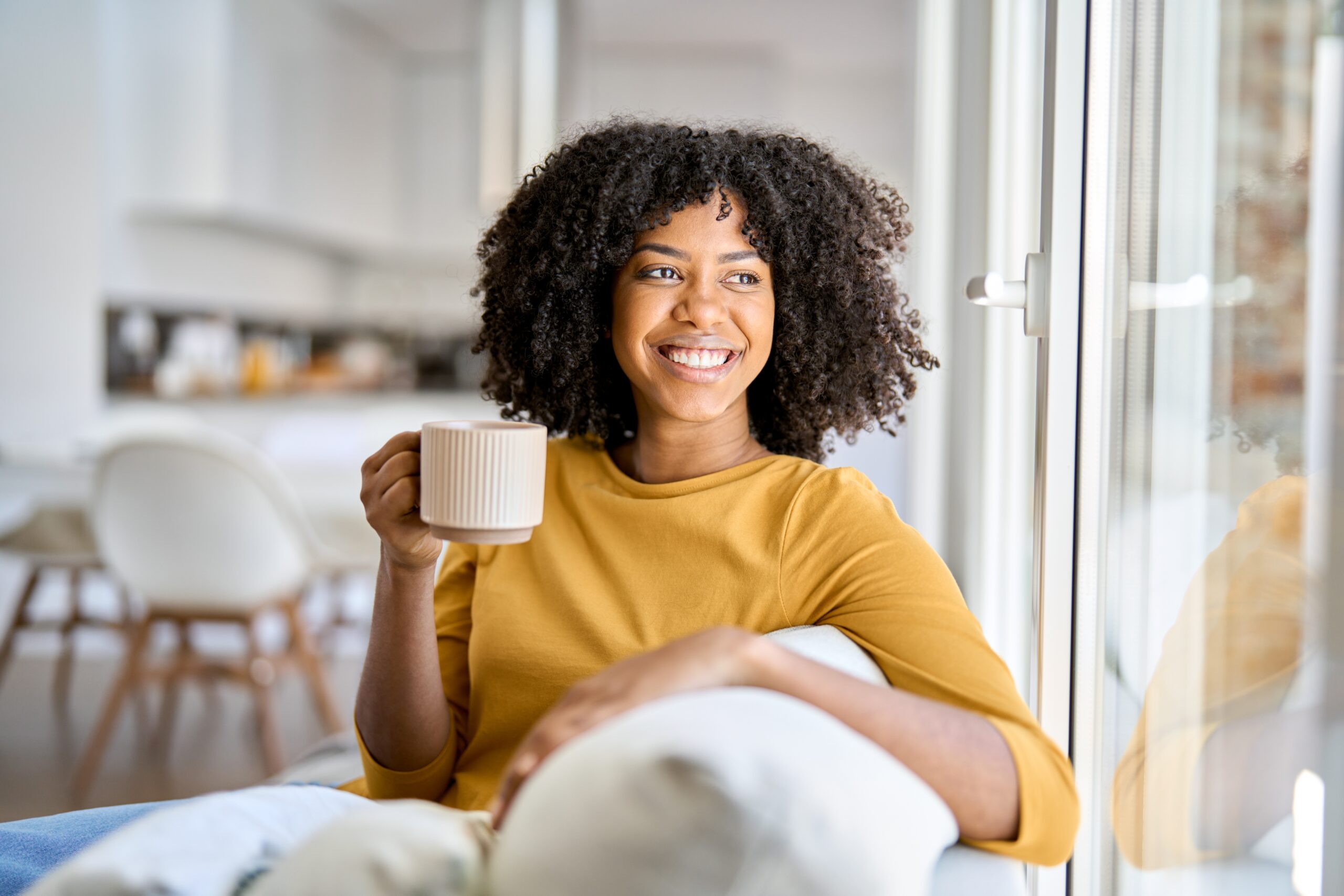 Young woman smiling with a mug in her hand