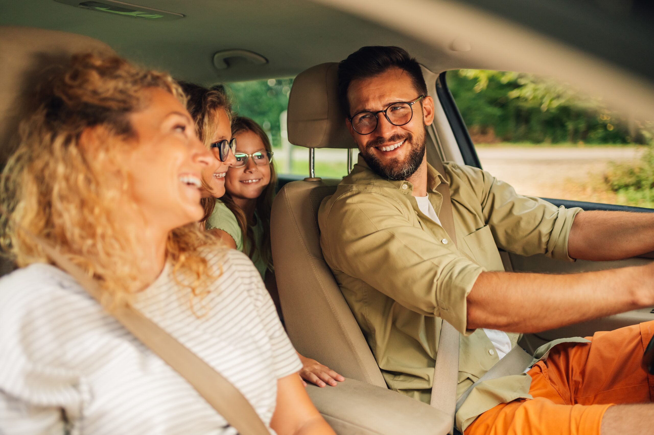 Young family in a car smiling at eachother