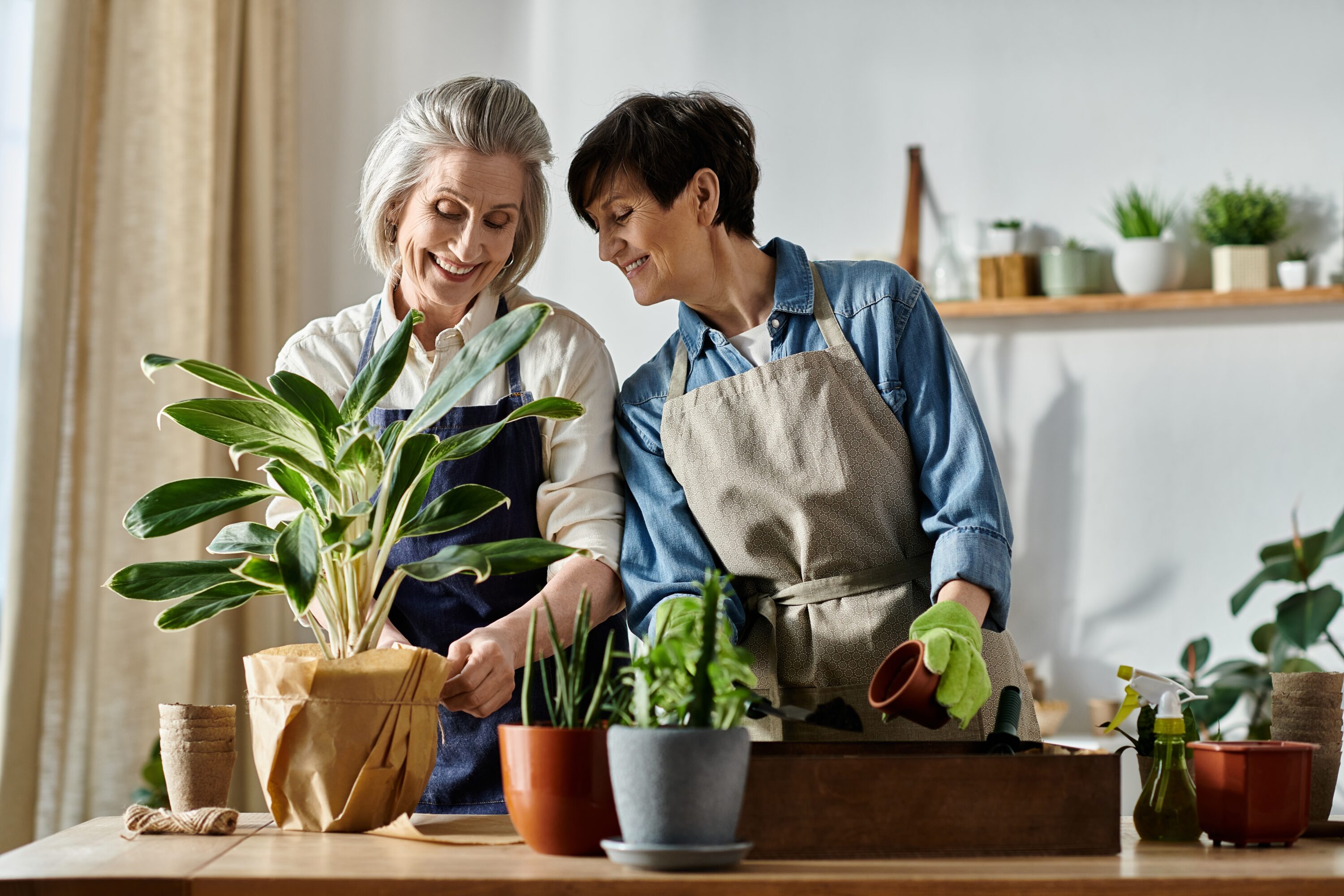 Two,Women,In,Aprons,Caring,For,A,Potted,Plant