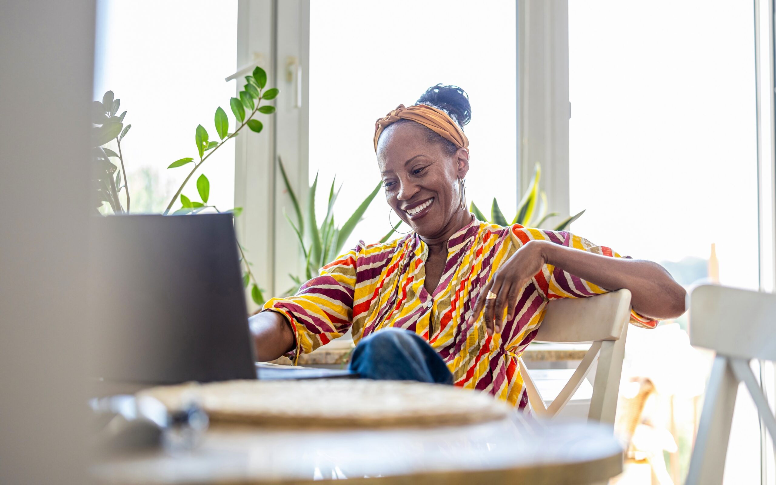 A woman smiling at her laptop.
