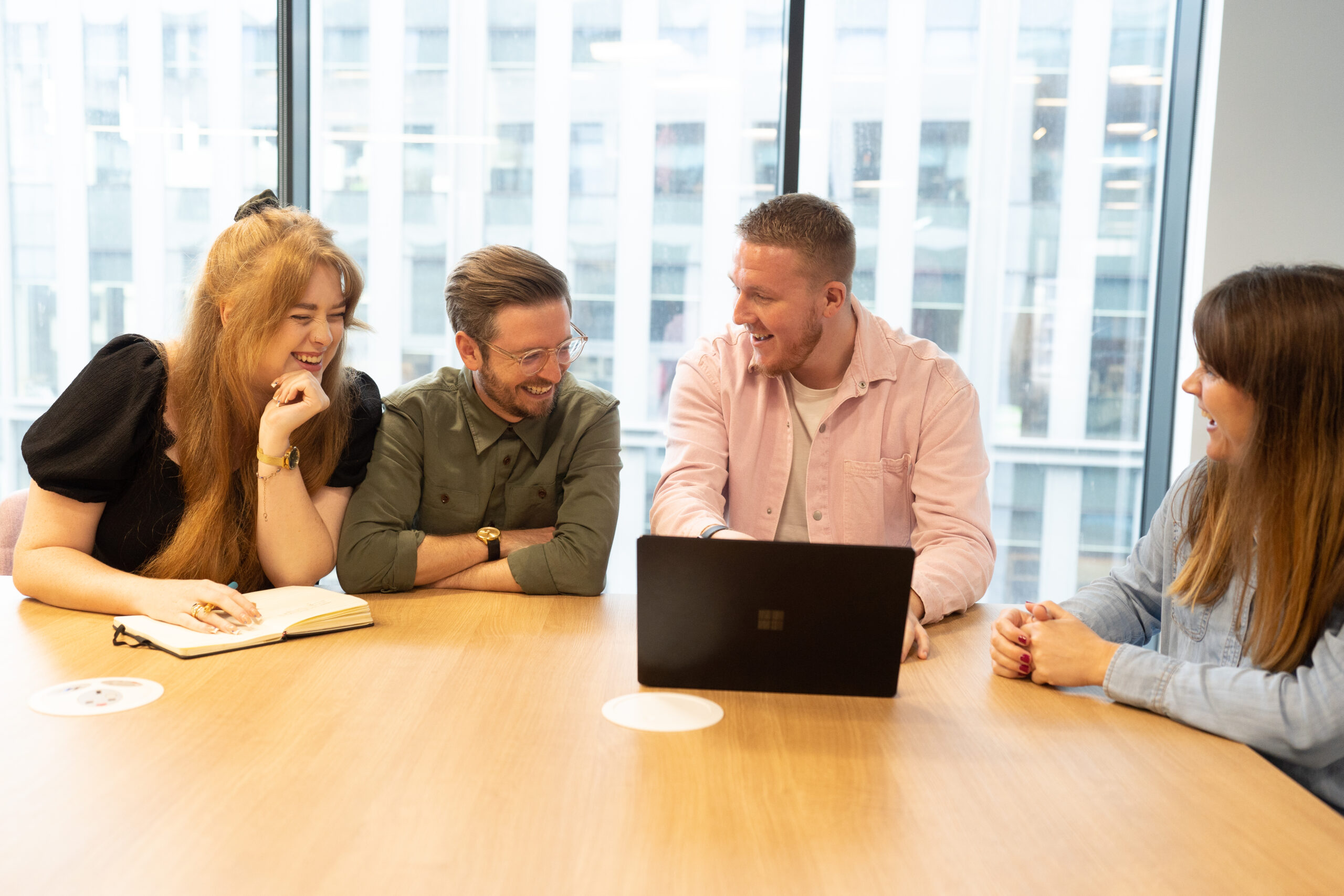 Group of Hodge staff smile around laptop