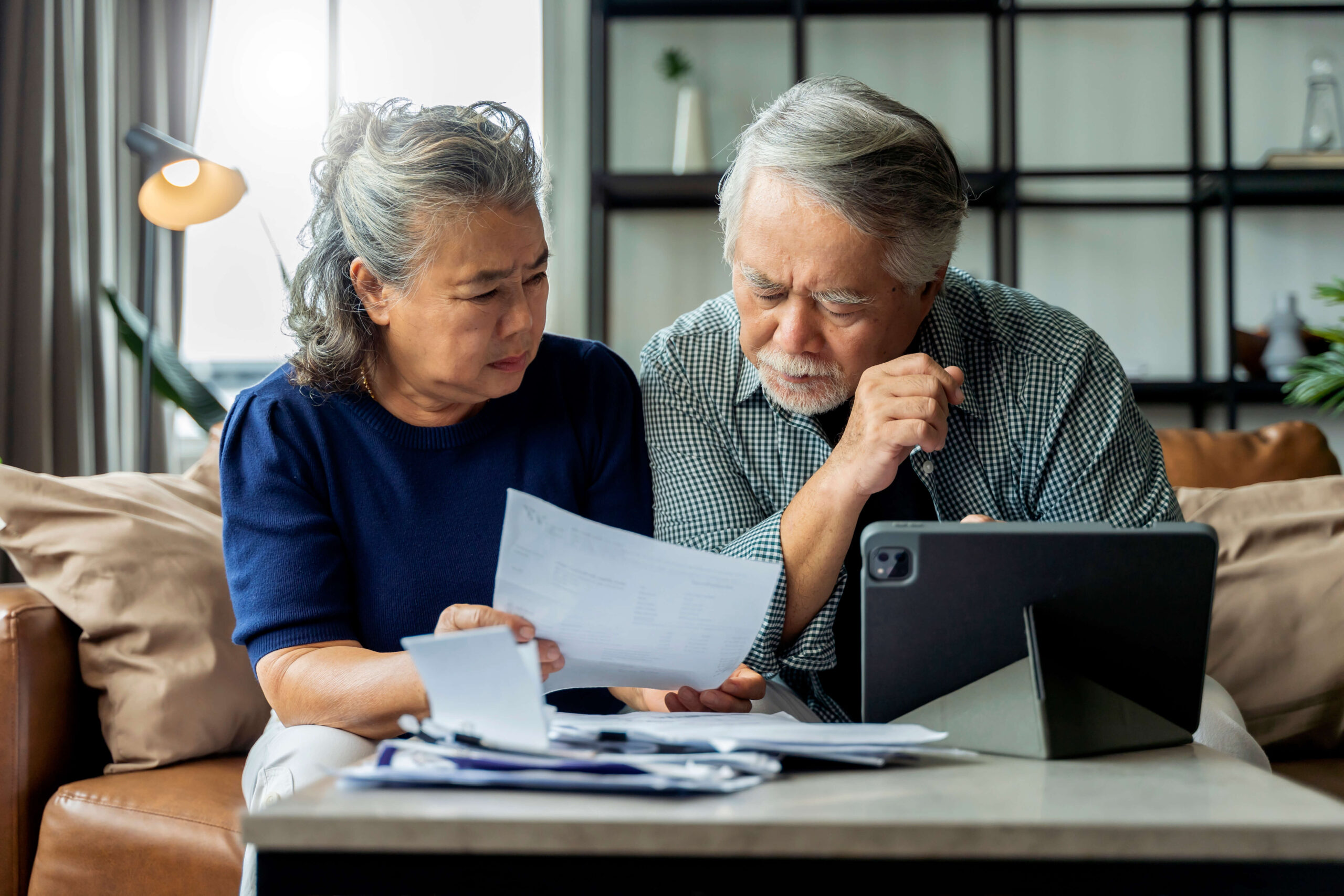 Mature couple looking concerned at finances