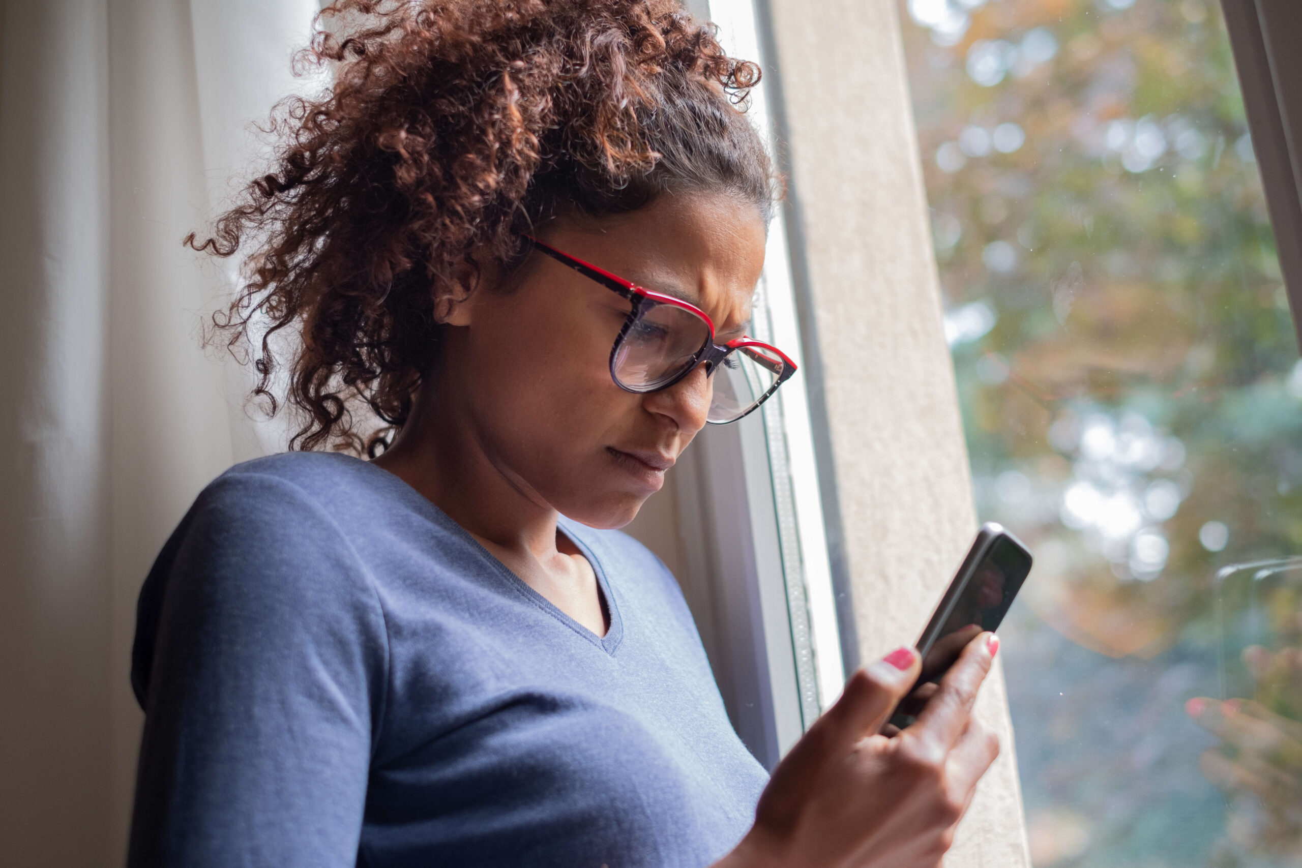 Middle aged woman looking concerned at phone