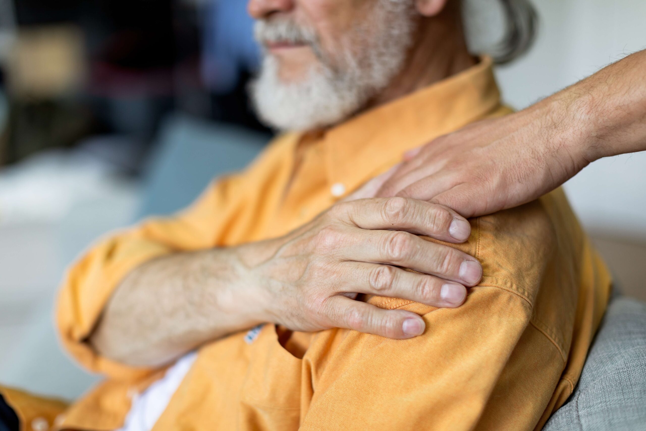 Person touches mans shoulder, providing comfort