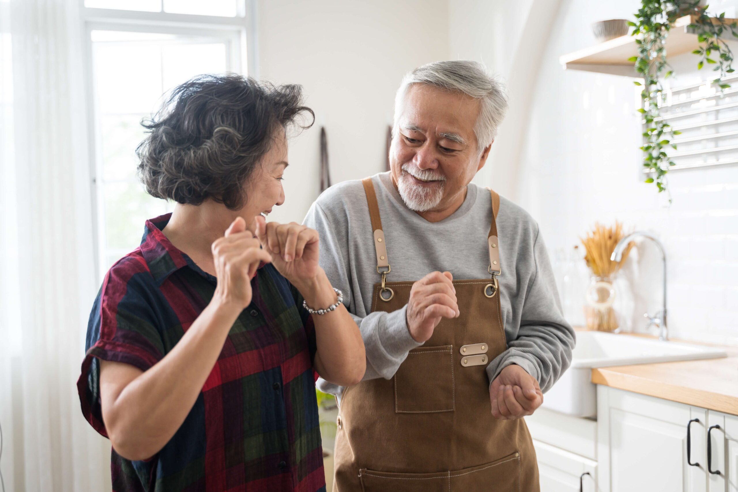 mature asian couple dancing kitchen