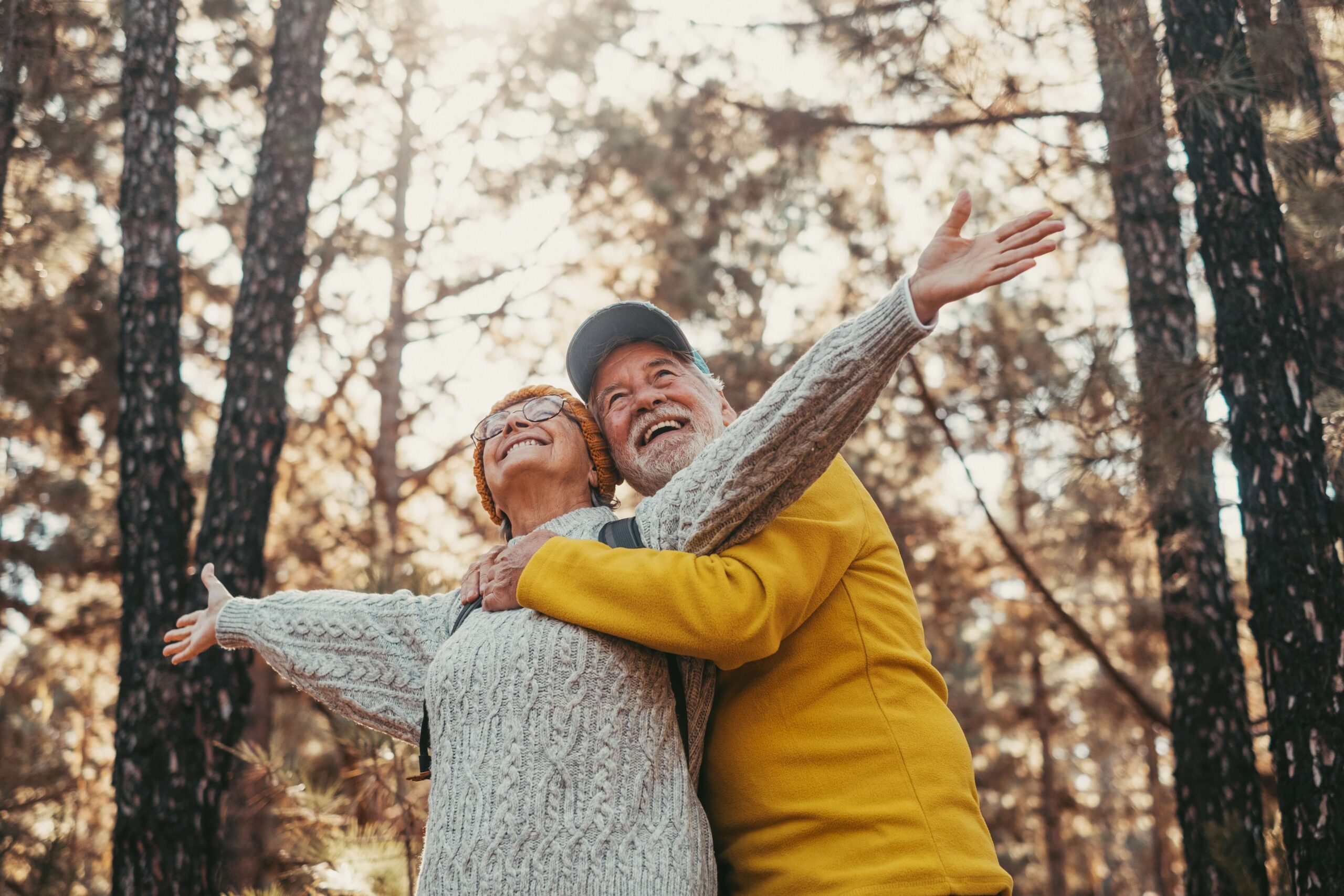 mature couple in woods arms out