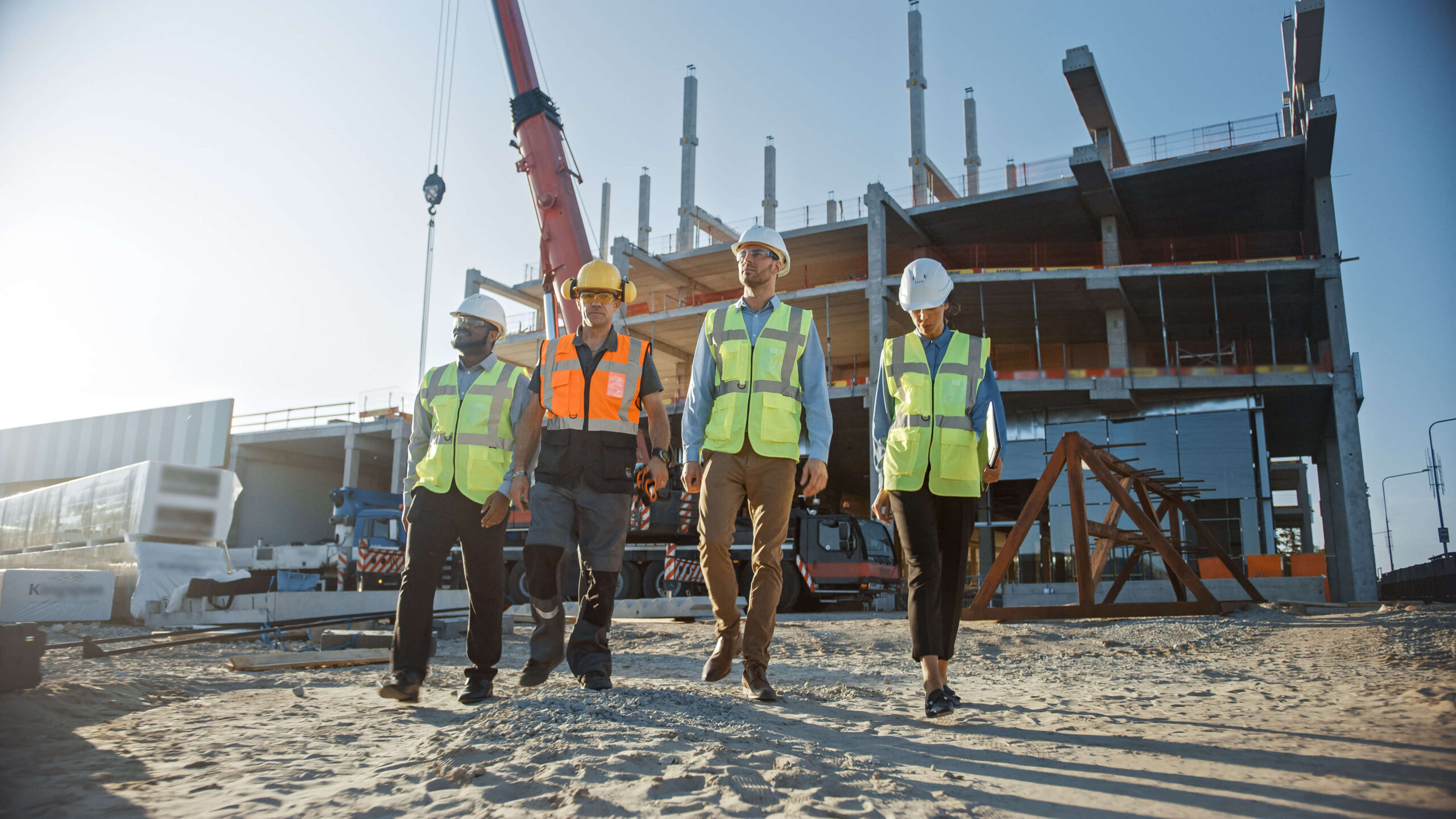 Group of construction workers walk across building site