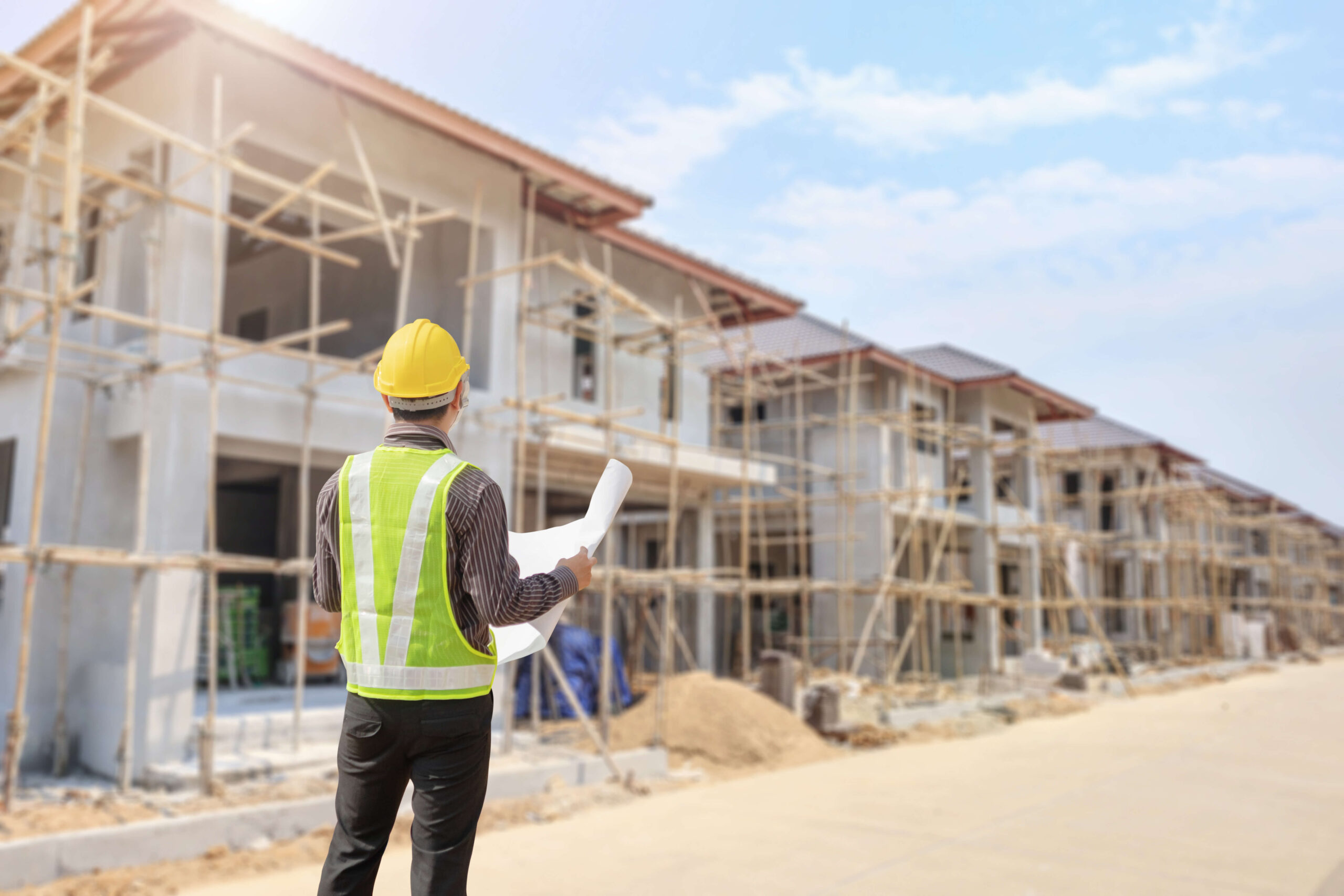 Architect looks at plans while on a development site