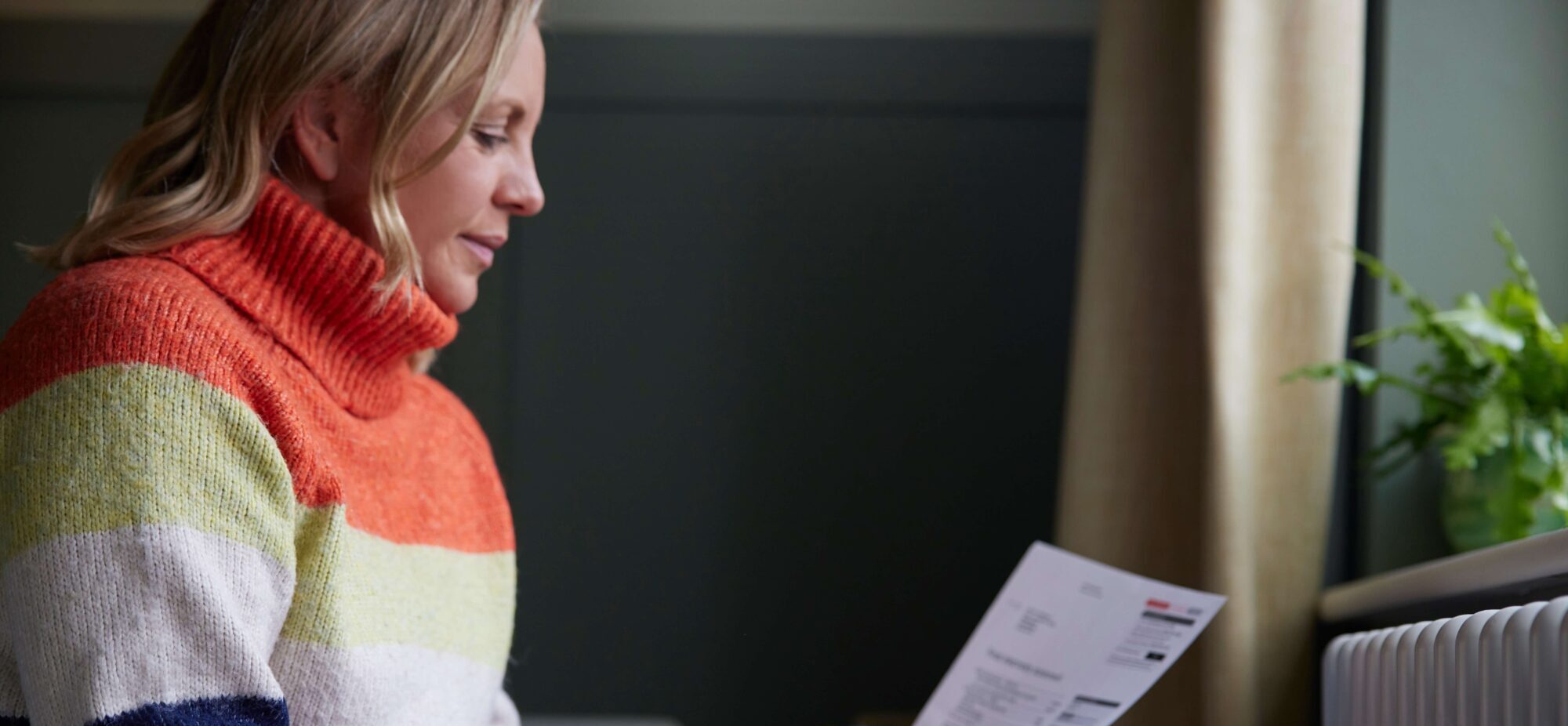 Women stares at bills in cosy jumper