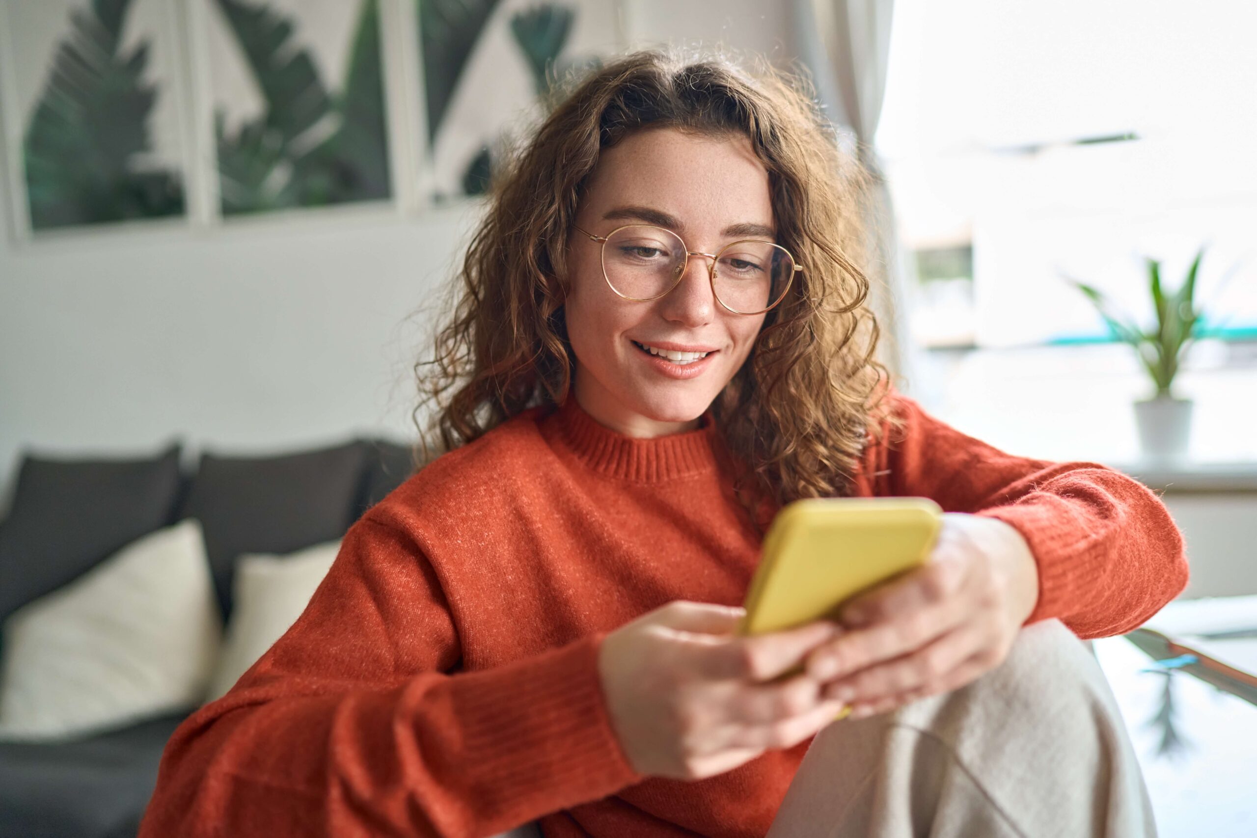 Young woman with glasses looking at phone