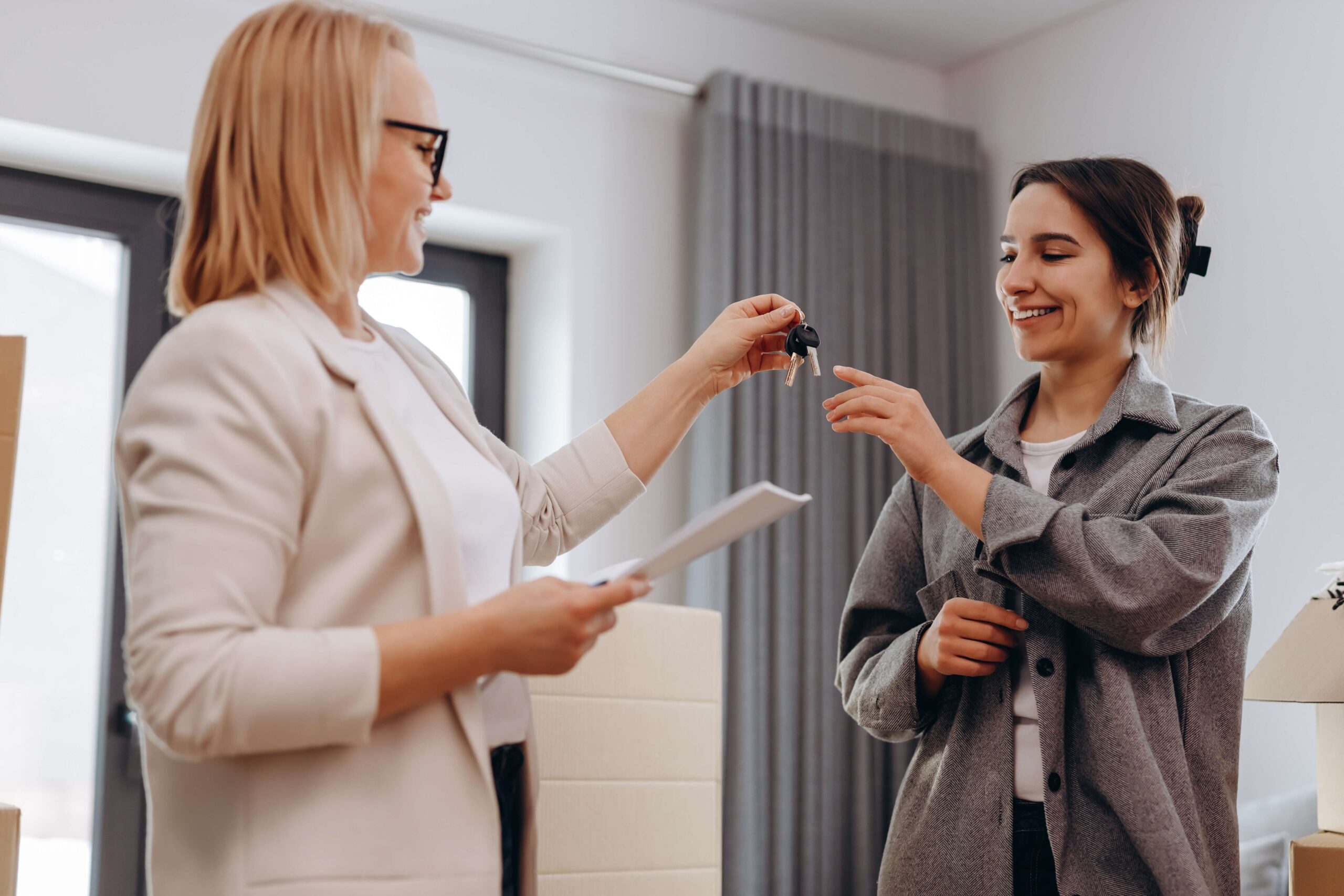 Estate agent giving young woman keys to new home