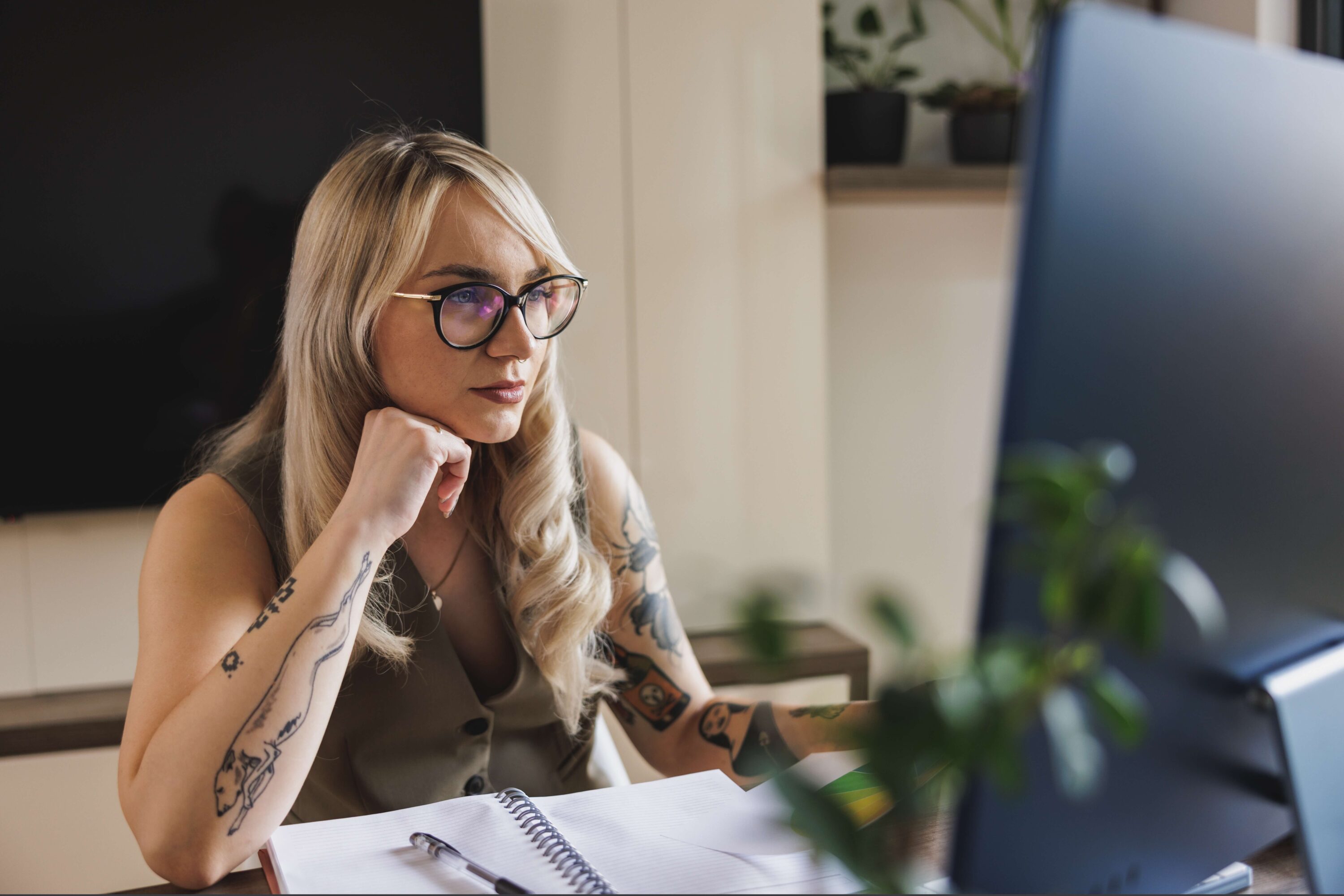 Tattooed woman in office looking at computor