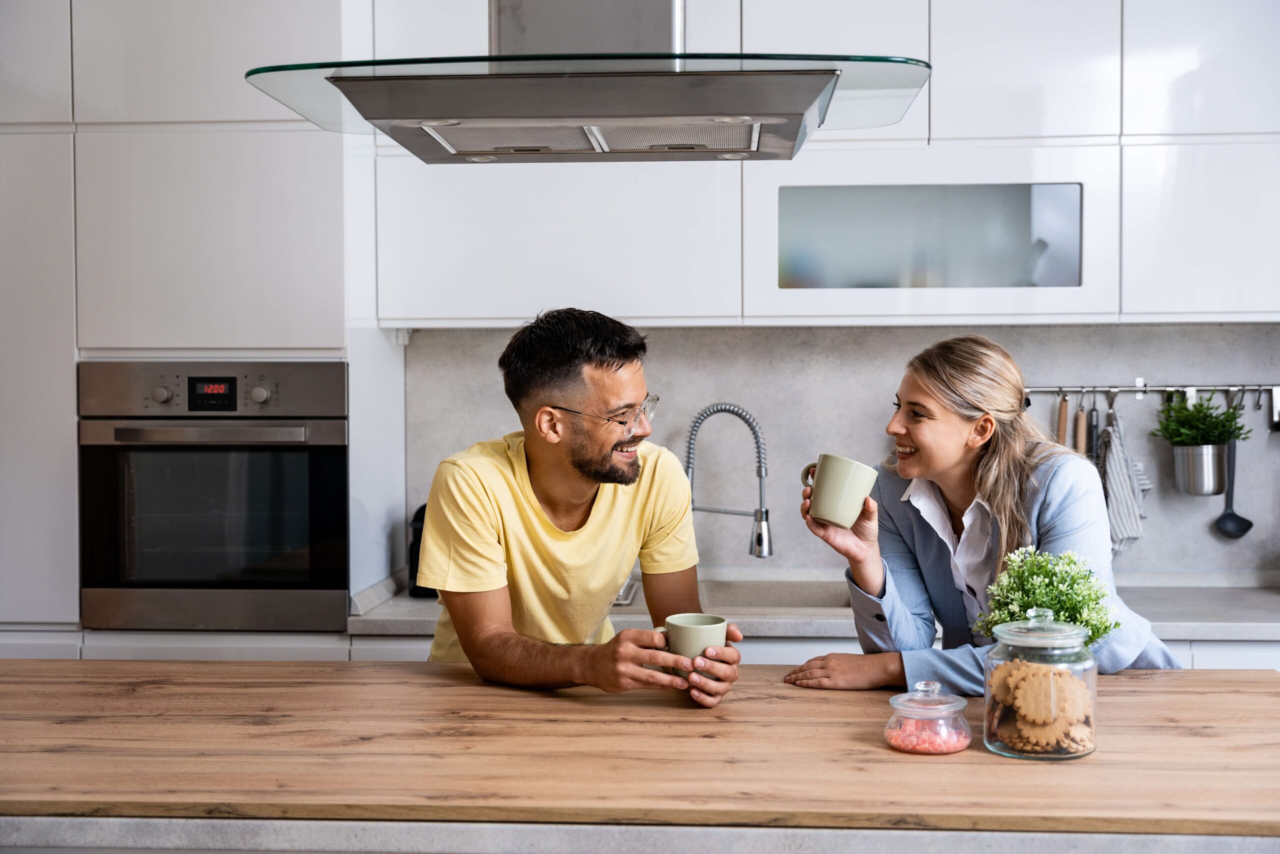Young couple in kitchen having tea
