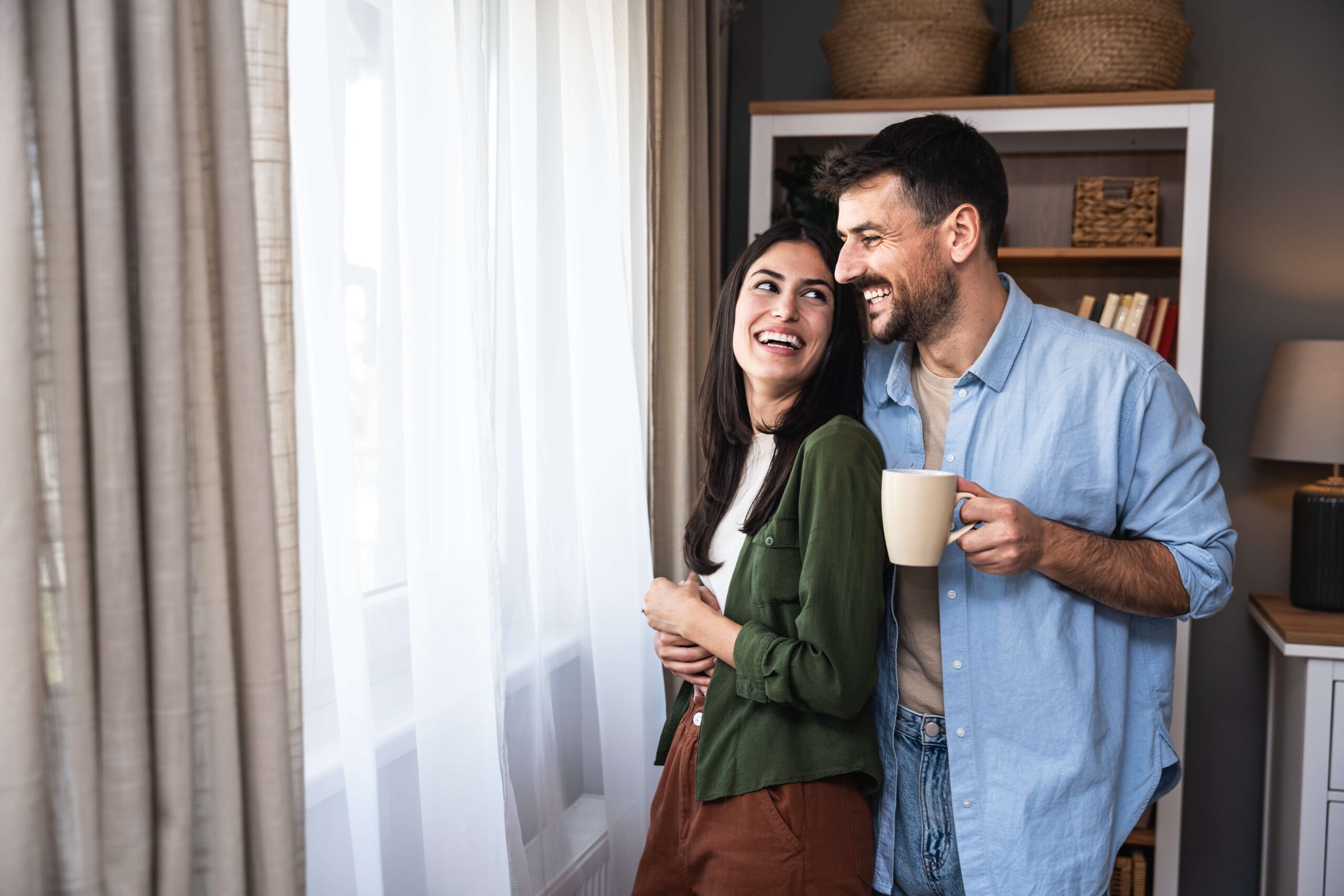 Young couple happy looking out of window