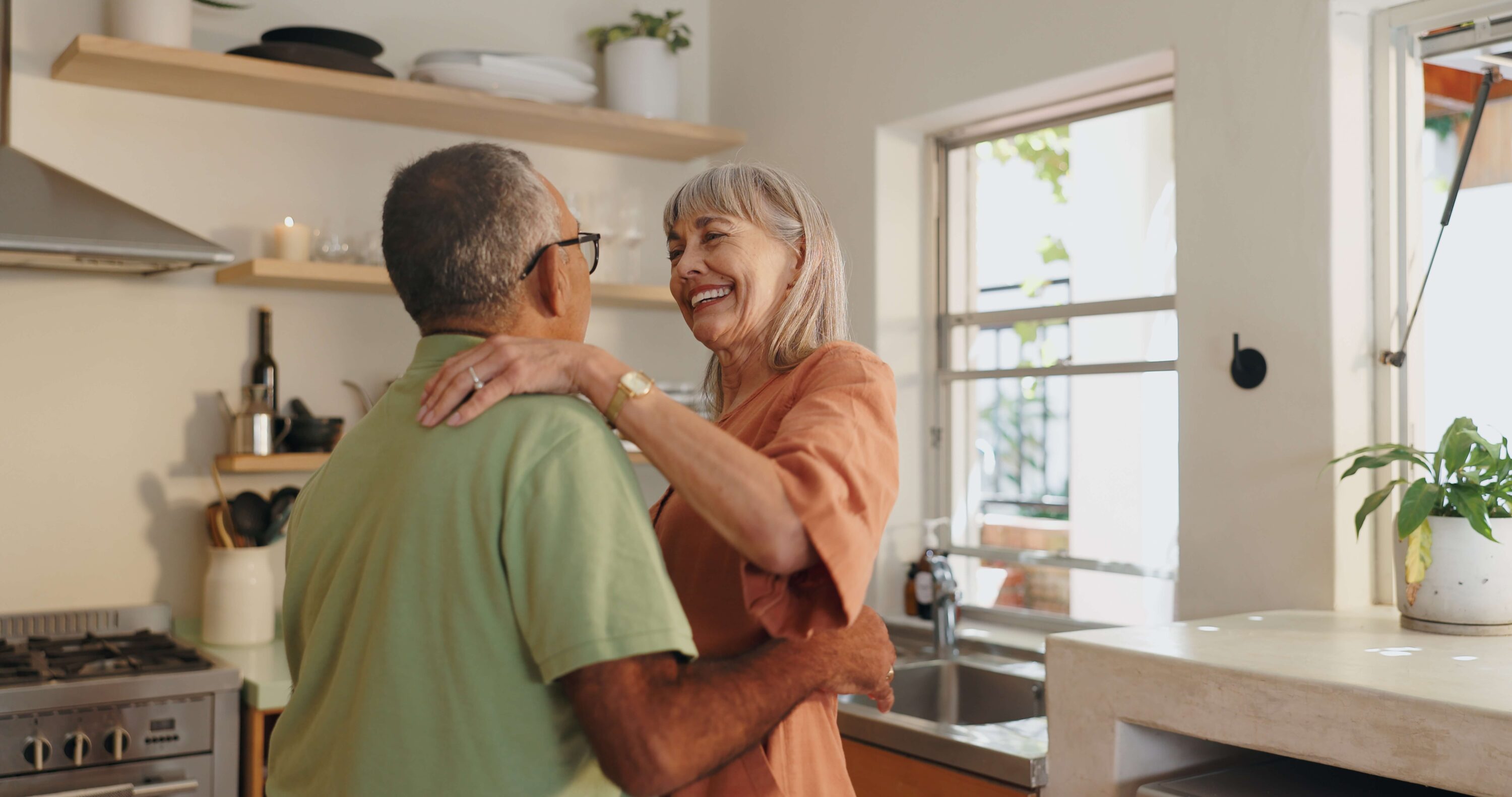 Mature couple happy hugging in kitchen