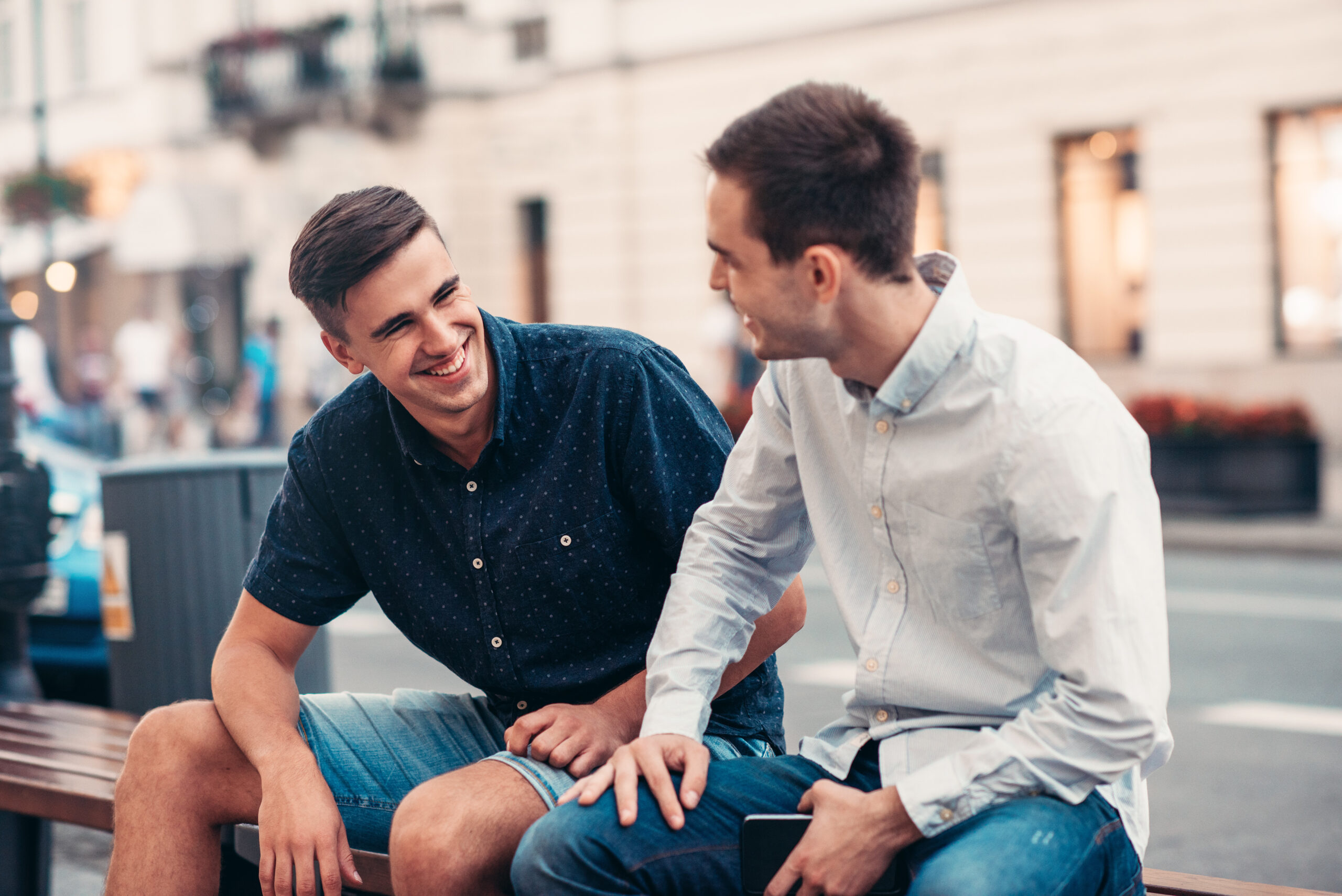 Two young adults chatting on a bench