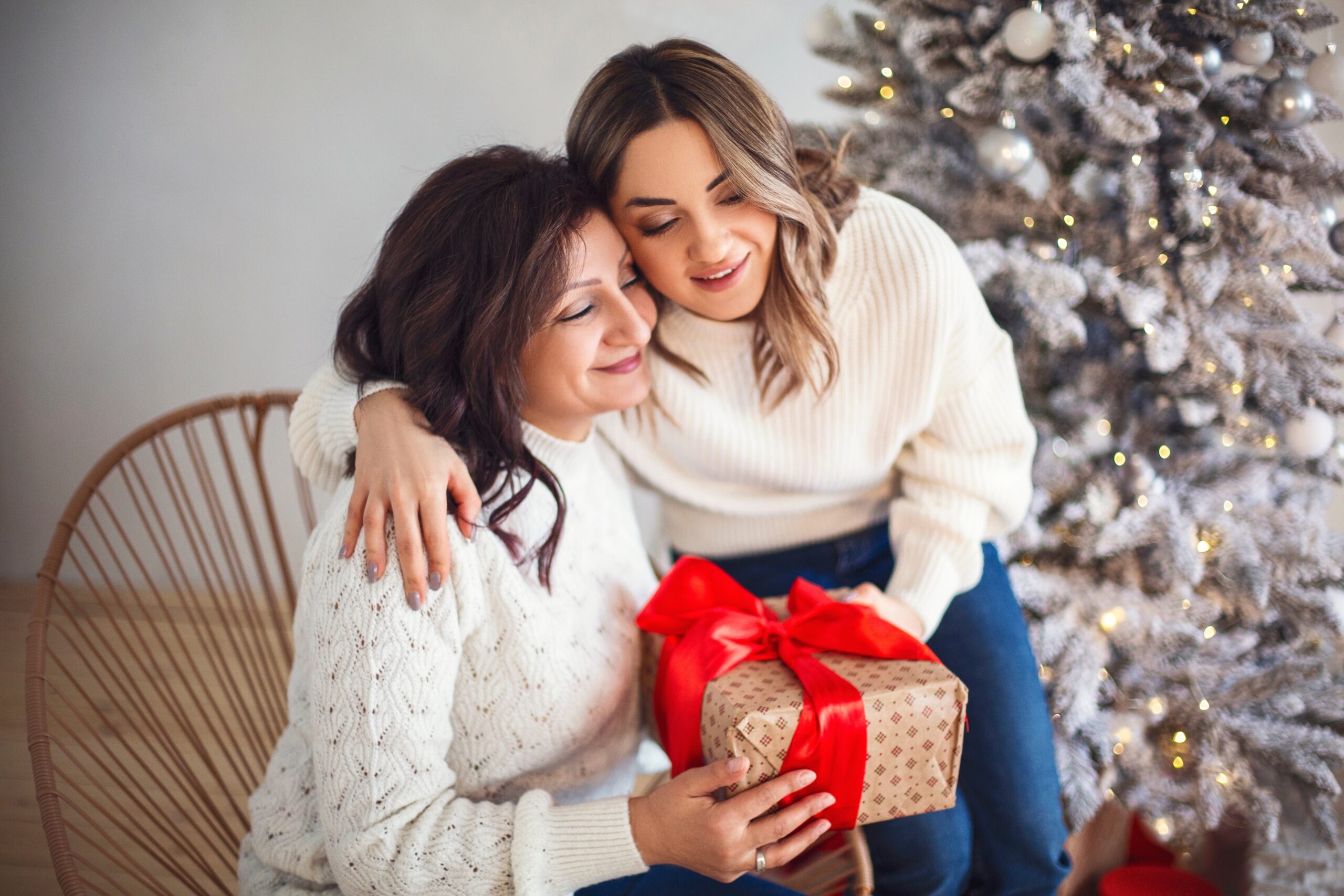 Mother and daughter open a gift at Christmas