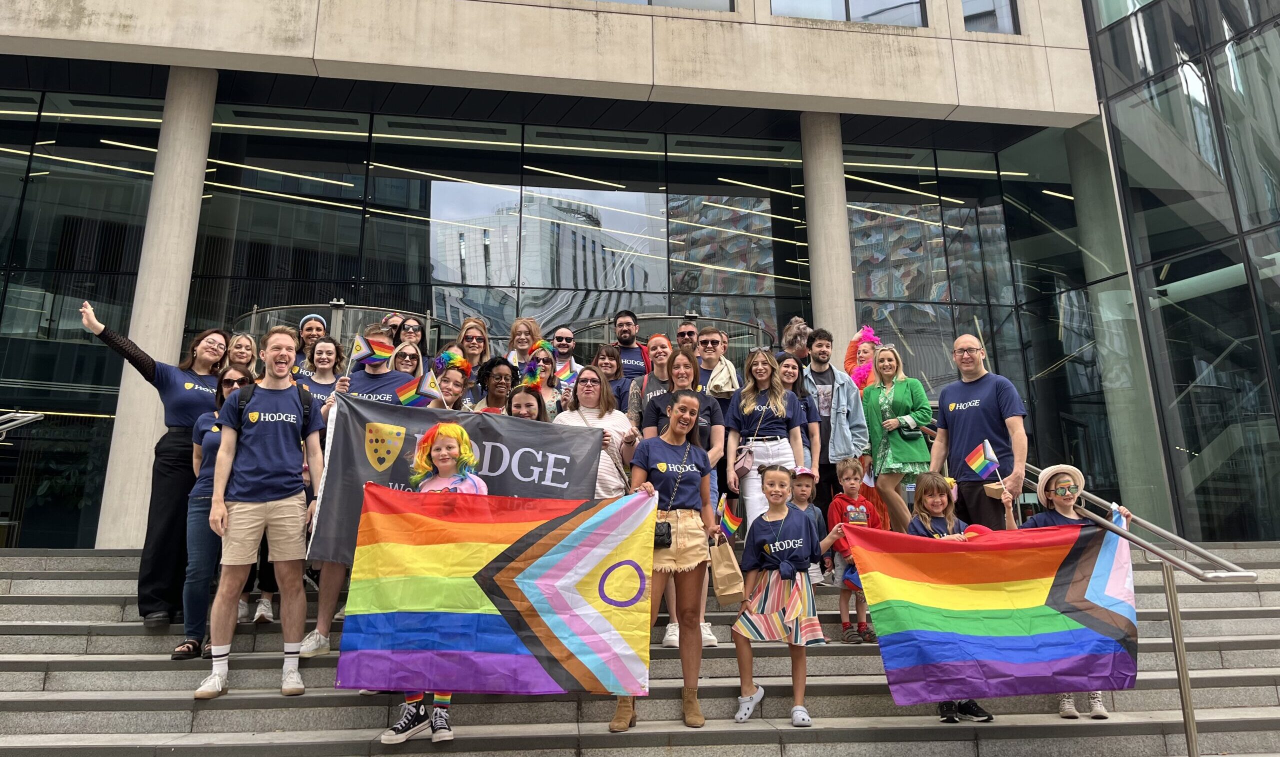 A group of Hodge employees with Pride flags smiling