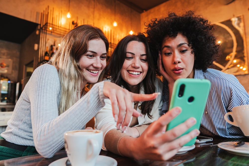 Three women looking at a phone