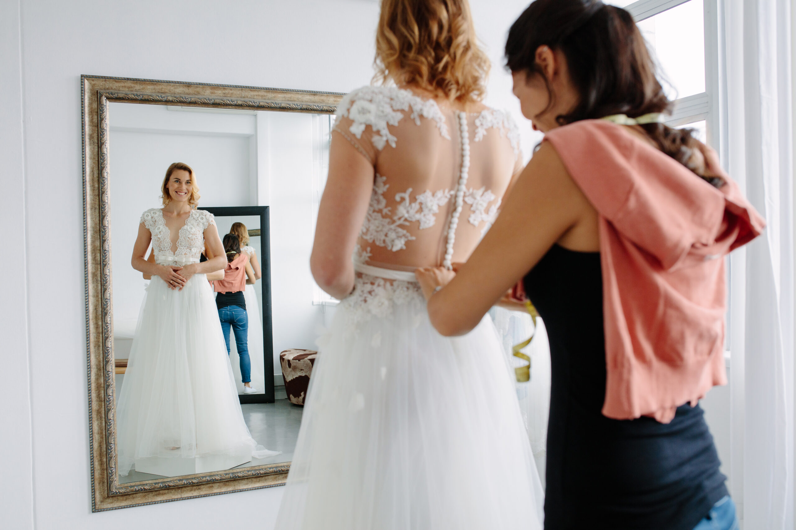 Bride does up dress in mirror