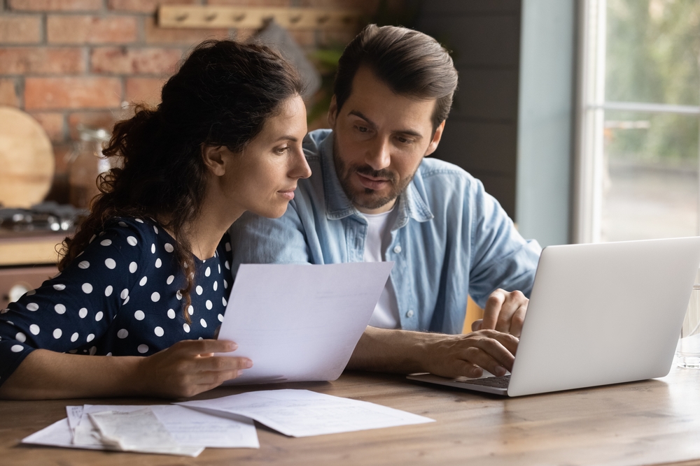 Couple looking at a laptop and documents