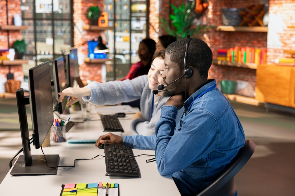 Two members of a call centre team collaborating