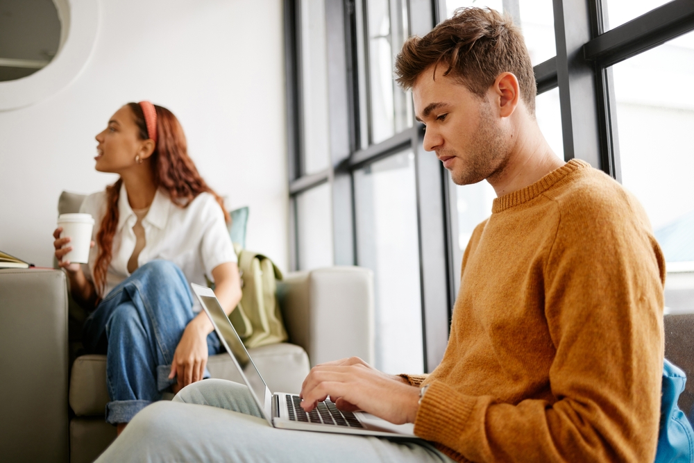 Man on a laptop and woman drinking coffee