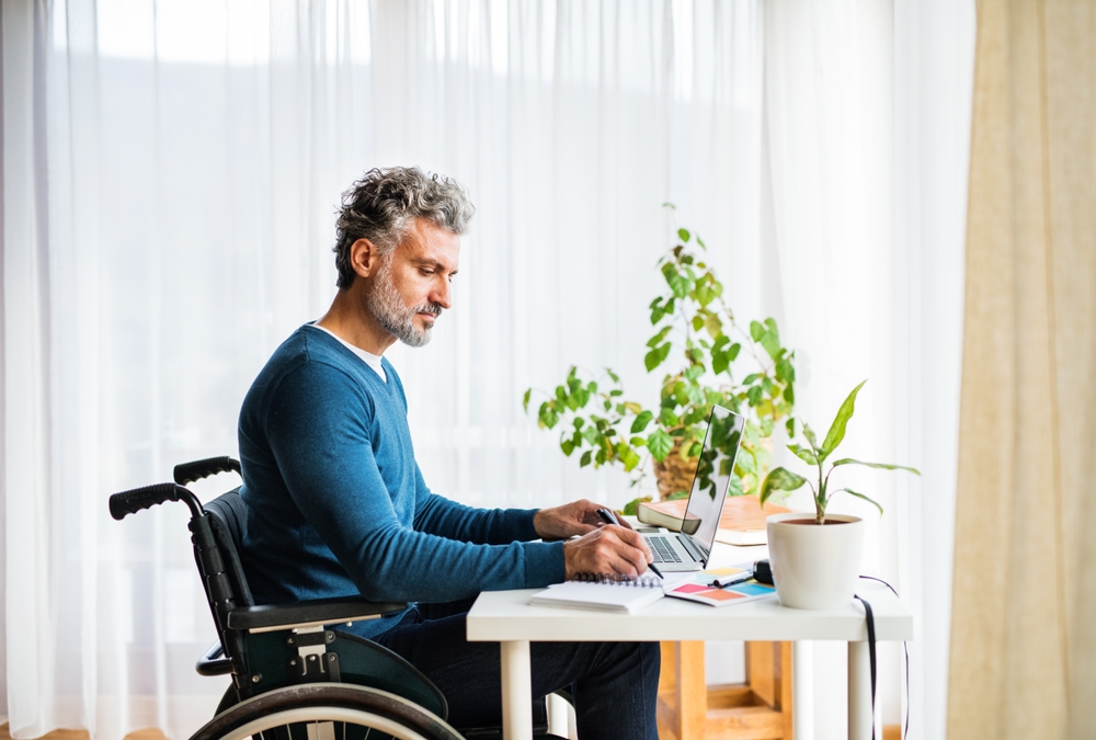 man in wheelchair at desk