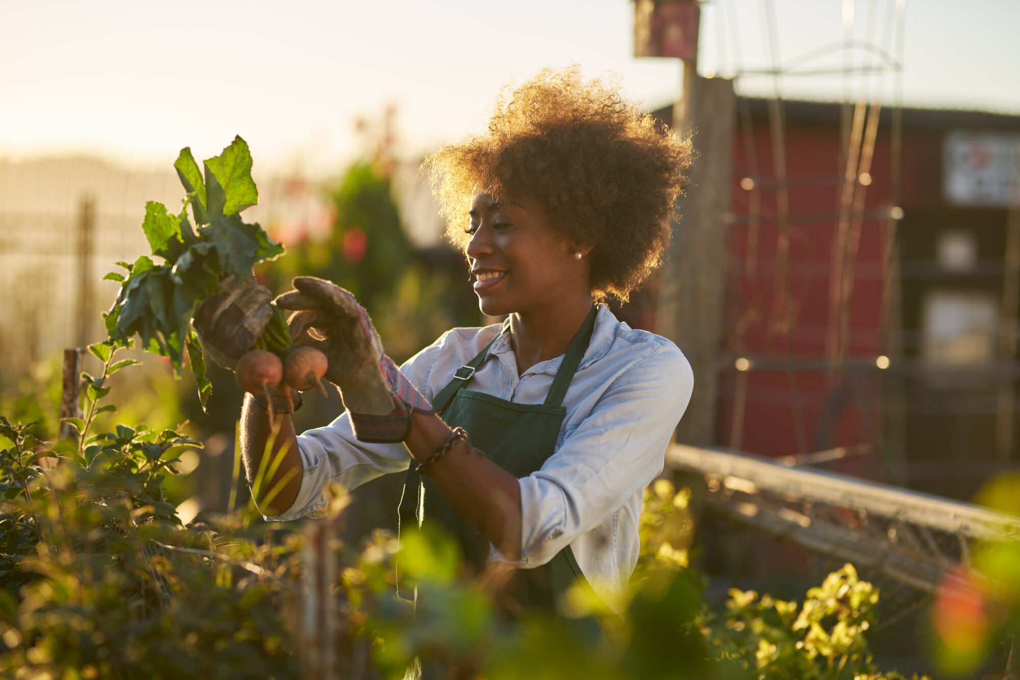 A woman smiling whilst gardening.