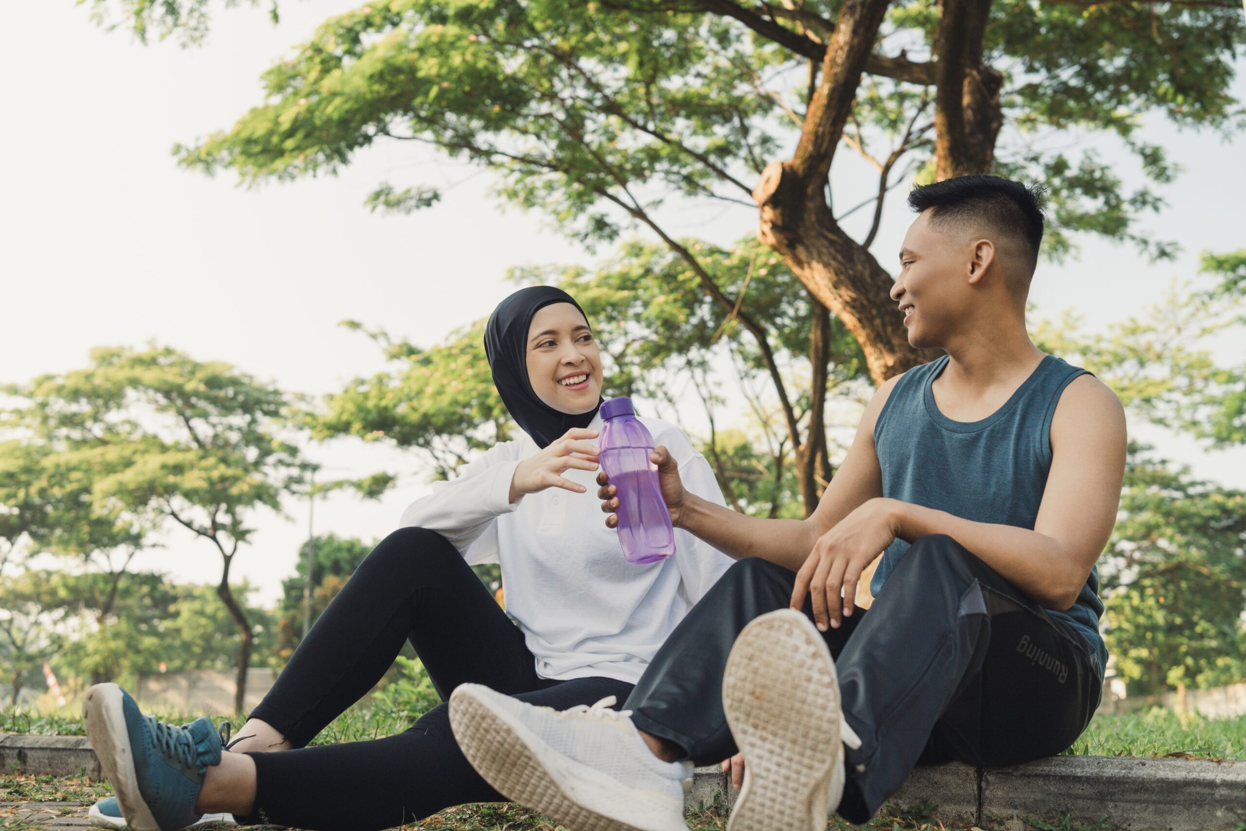 Two people wearing leisurewear, smiling at eachother.