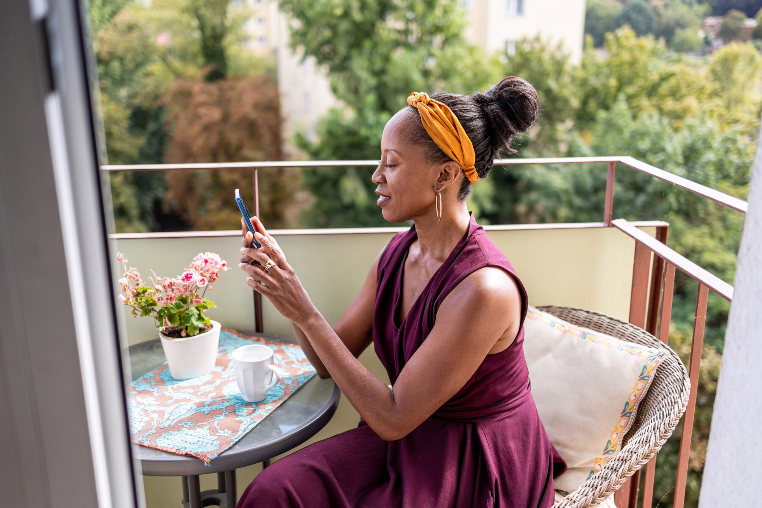 A woman sat on a balcony checking her phone.