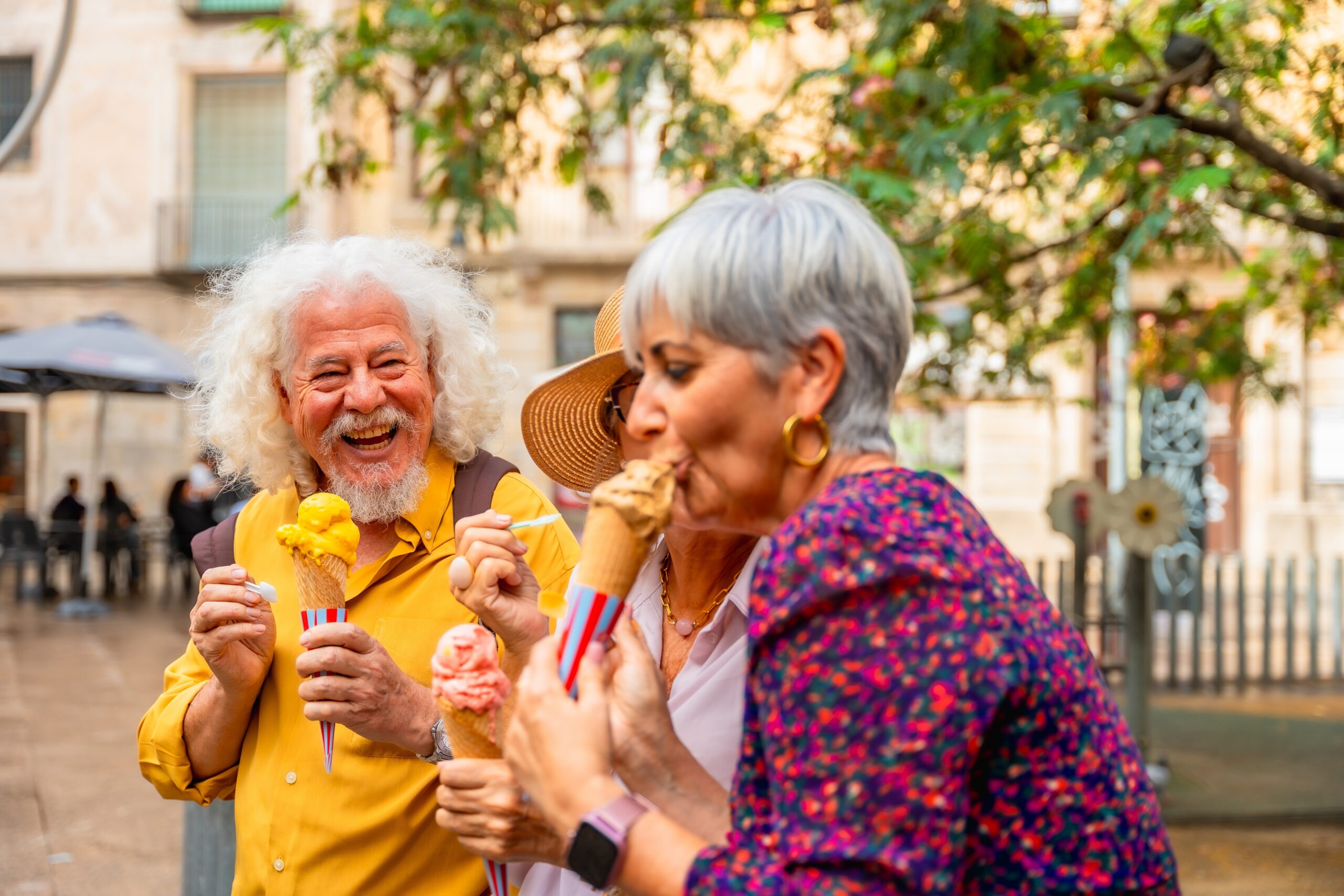 Two people smiling at eachother whilst eating ice cream.